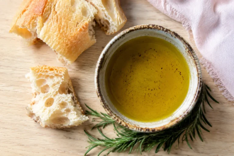 Bowl of olive oil with rustic bread and rosemary for an article about olive oil for PCOS