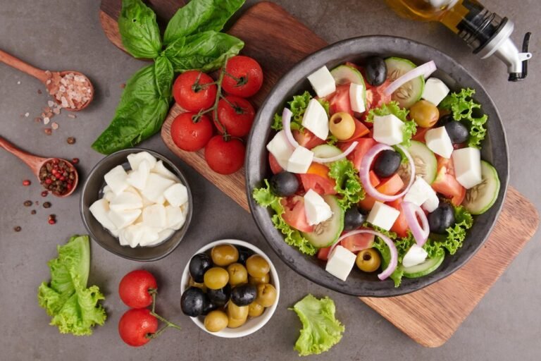 A Mediterranean-inspired salad with fresh tomatoes, cucumbers, red onion, black olives, and feta cheese.